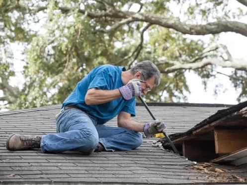 older man on roof diy